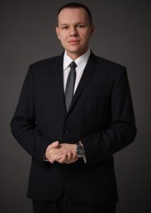 Dawid Sojka, mężczyzna w garniturze i białej koszuli